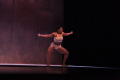 Photograph: [Solo dancer squatting on stage]