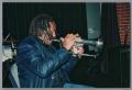 Photograph: [Photograph of a man facing the audience and playing trumpet]