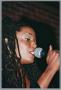 Thumbnail image of item number 1 in: '[Photograph of soul artist Rhea singing into a microphone]'.