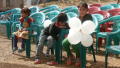 Primary view of Child holding balloons at the first anniversary of late Behon Shilshi
