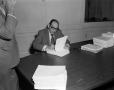 Photograph: [Abe Herman signing contracts]