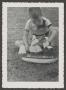 Photograph: [Photograph of Tim Williams playing with a toy boat]