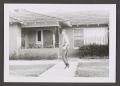Photograph: [Photograph of a young man running towards a house]