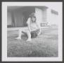 Photograph: [Pam Williams sitting near a house with a dog]