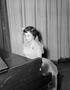 Photograph: [Photograph of a girl in a dress sitting at the piano]