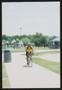 Photograph: [Cyclist in yellow riding along a park path: Lone Star Ride 2003 even…