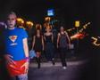 Photograph: [Four individuals walking down a street at night with blurred lights]