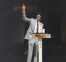 Photograph: [Televangelist Mike Evans giving a sermon behind a cross lectern]