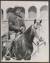 Photograph: [A man on horseback and smiling, at a livestock show]