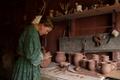 Photograph: [Woman looking at pottery]