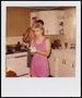 Photograph: [Woman wiping her hands in a kitchen]