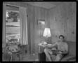Photograph: [Shirtless man in a wood-paneled room]