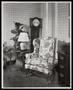 Photograph: [A patterned chair in front of a clock]