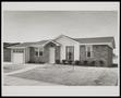 Photograph: [Exterior of a house with a small garage]