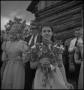 Photograph: [Bridesmaid holds bouquet at country wedding]