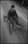 Photograph: [Photograph of a boy riding in a wagon]
