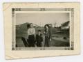 Photograph: [Bill Findley, Frank Cuellar Jr., and Julia Cuellar in front of house…