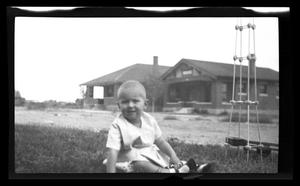 Primary view of object titled '[John Williams, sitting in a yard]'.