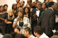 Photograph: [Choir and conductor performing on stage]