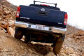 Photograph: [Back of a Nissan Frontier truck driving down a rocky slope]