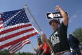 Primary view of [Man holding American flag with arm raised]