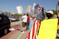 Primary view of [Protesters holding signs next to traffic]
