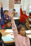 Photograph: [Students raise their hands during a class]