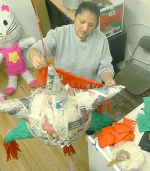 Primary view of object titled '[Woman decorates a piñata]'.