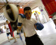 Photograph: [Boy wearing blue boxing gloves]