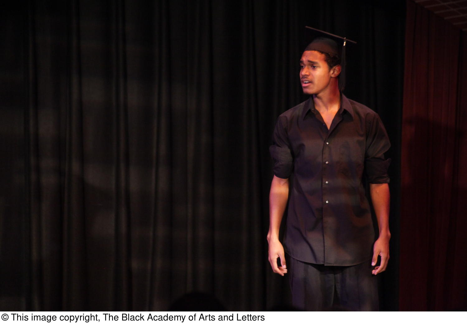 [Performer Wearing Graduation Cap on Stage]
                                                
                                                    [Sequence #]: 1 of 1
                                                