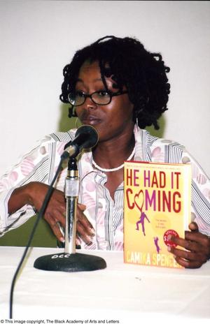 [Camika Spencer holding her book, "He Had it Coming"]