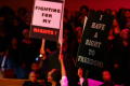 Photograph: [Performers holding signs on stage]