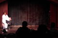 Photograph: [Performer sitting on stage]