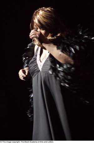[Singer with a black feather boa]