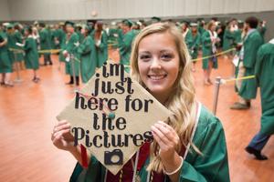Primary view of object titled '[Graduating Student Posing with Decorated Mortarboard]'.