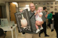 Thumbnail image of item number 1 in: '[Man Holding Poster In One Hand and Baby In Other]'.