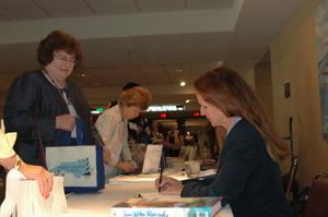 [Woman autographing books at the 2006 CSLA conference]