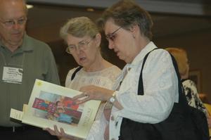 [Conference guests looking over books for sale]