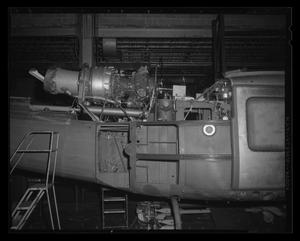 [Photograph of a side view of a UH-1E Iroquois helicopter assembly]