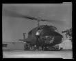 Thumbnail image of item number 1 in: '[Photograph of a man climbing into a YUH-1D Iroquois helicopter]'.