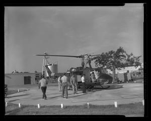 [Photograph of individuals working on a YUH-1D Iroquois helicopter, 2]