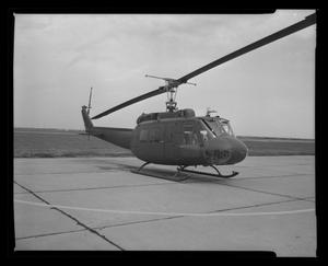 [Photograph of a UH-1E Iroquois helicopter parked on a concrete surface]