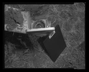 [Photograph of a clipboard leaning against a helicopter part]