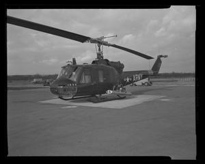 [Photograph of a side view of a UH-1C Iroquois helicopter parked on a concrete surface, 2]