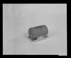 [Photograph of a small cylindrical helicopter part]