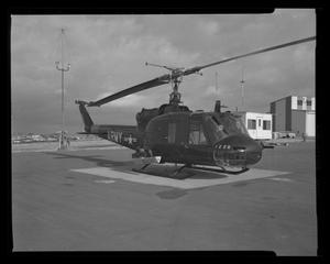 [Photograph of a side view of a UH-1C Iroquois helicopter parked on a concrete surface]