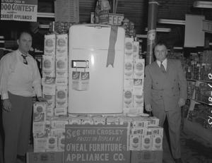 [Two Men Standing Next to a Refrigerator and Bags of Flour]