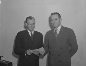 [Two Men Posing for a Photo Holding a Paper Slip]