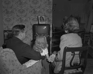 [A family watching television]