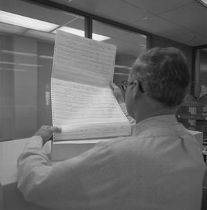 [Man reading a report, 2]